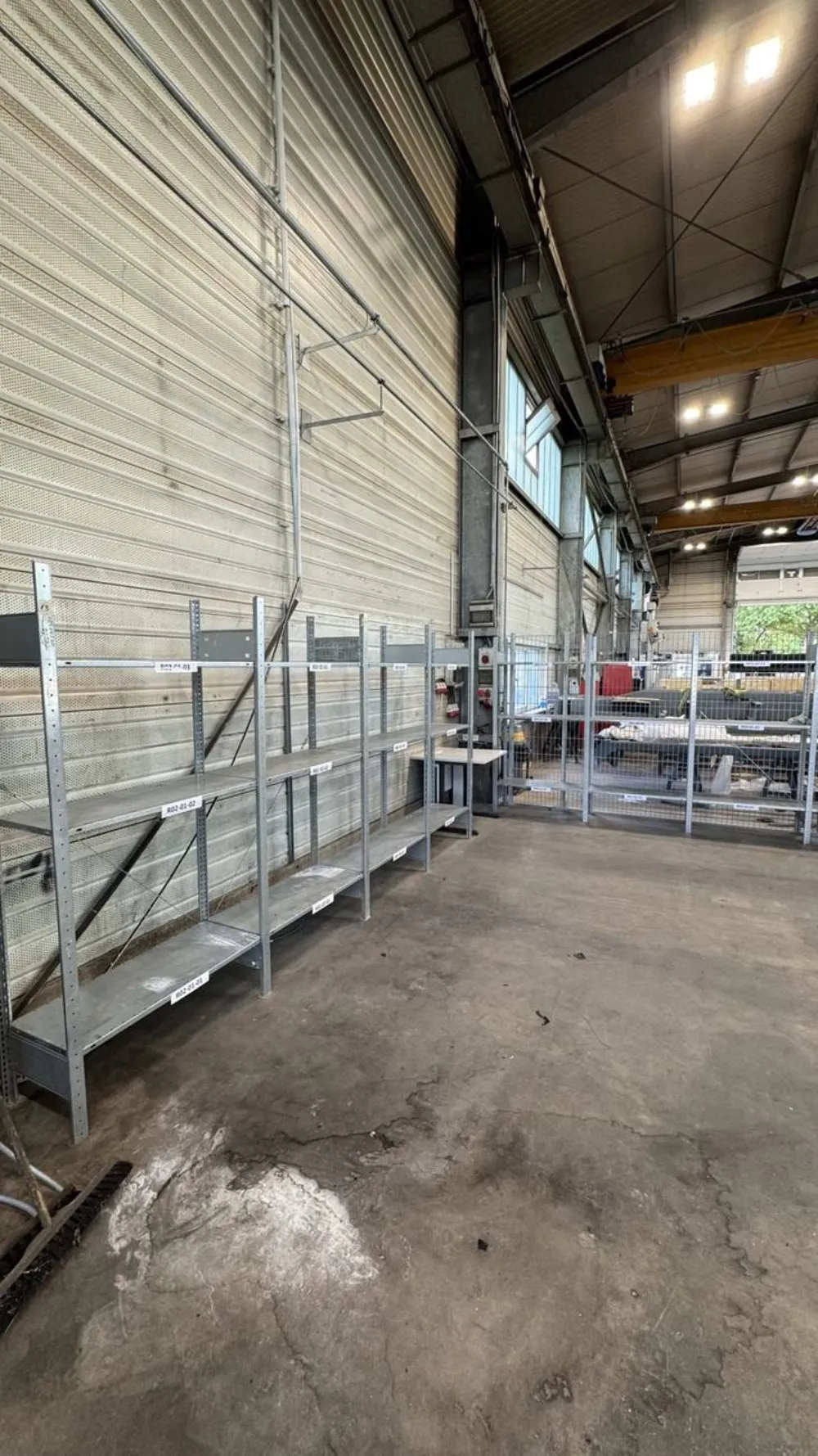 Neu aufgebaute, noch leere Regalreihen in der Halle mit Platzkennungen
