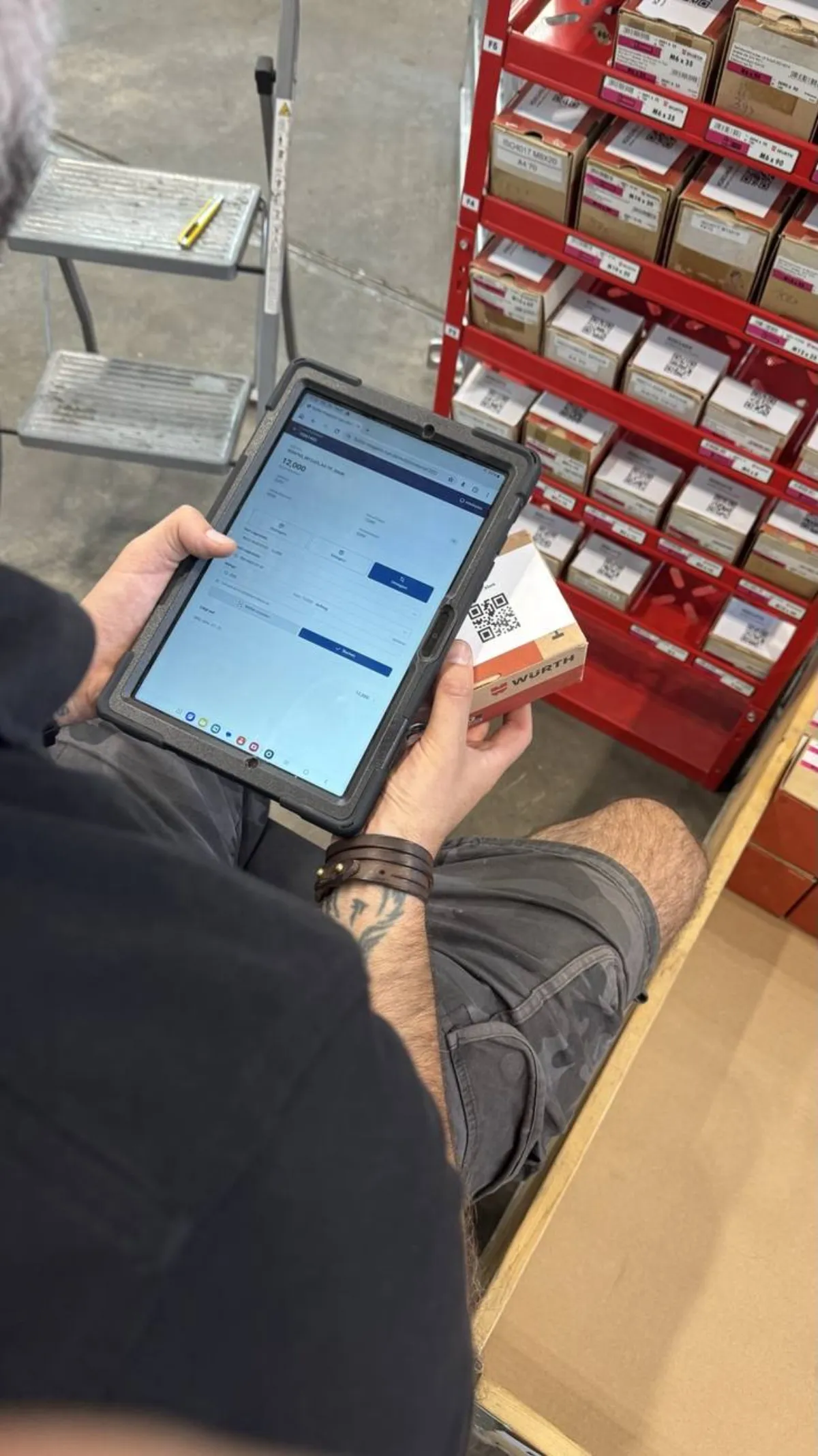 Mitarbeiter bucht Material am Tablet direkt vor dem Regal im neuen Magazin